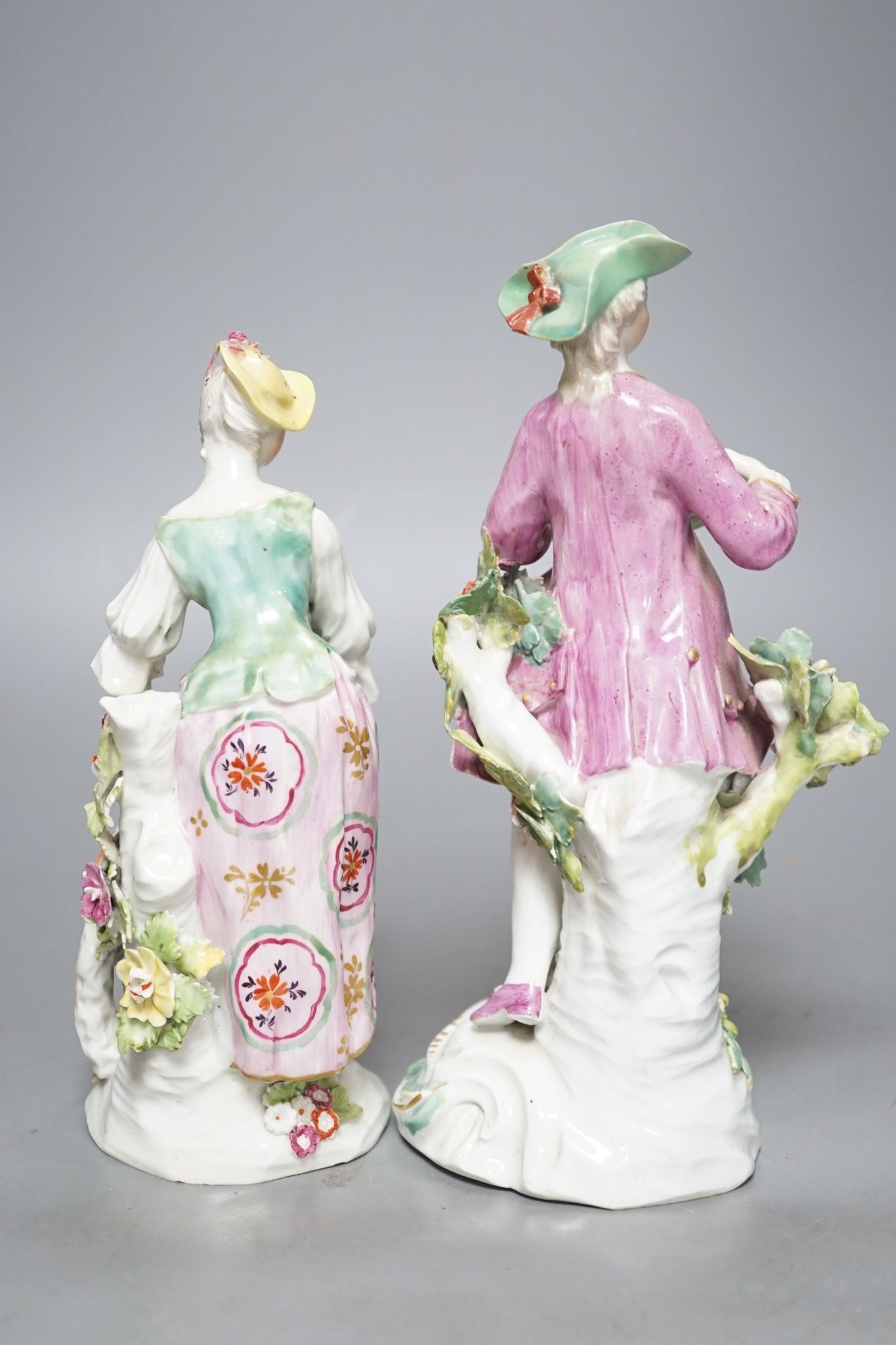 Two Derby porcelain figures of a gentleman holding a bird’s nest and a lady with a sheep, c.1760, 21.5 cms high.